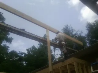 Carpenter setting a ridge beam over a new addition frame — Ice Dam Removal by Roofing Brothers in Santa Monica