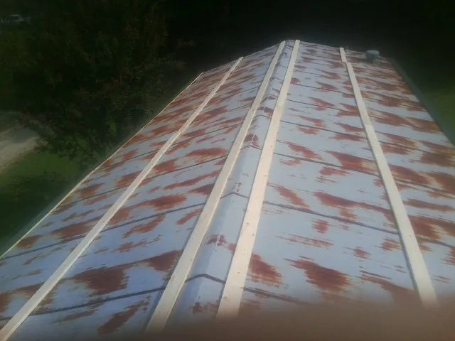 Rusted metal roof panels with new wood purlins before replacement — Storm Damage Roof Repair in Santa Monica by Roofing Brothers