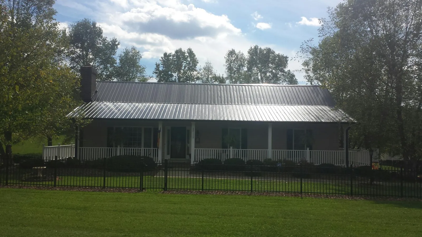 Gray metal roof on a brick ranch with a full width front porch — Gutter Guard Installation work by our crew in Santa Monica