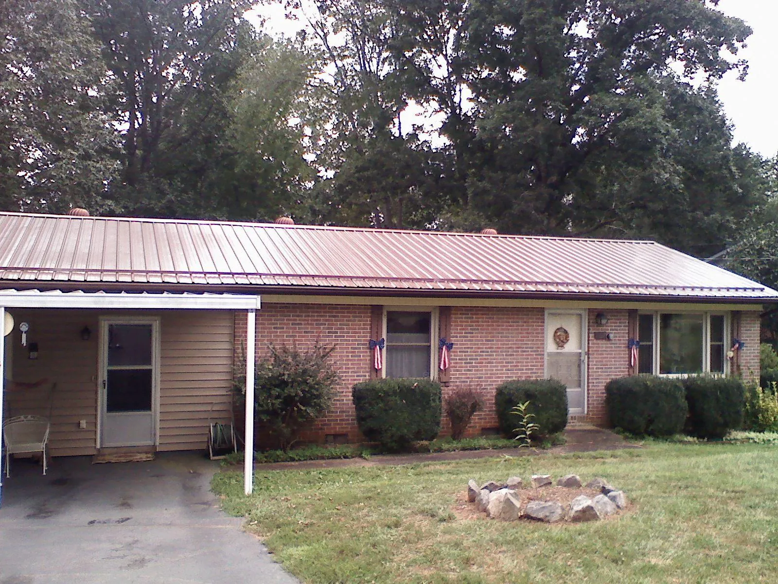 Bronze metal roof and carport on a brick ranch home — Roof Repair work by our crew in Santa Monica
